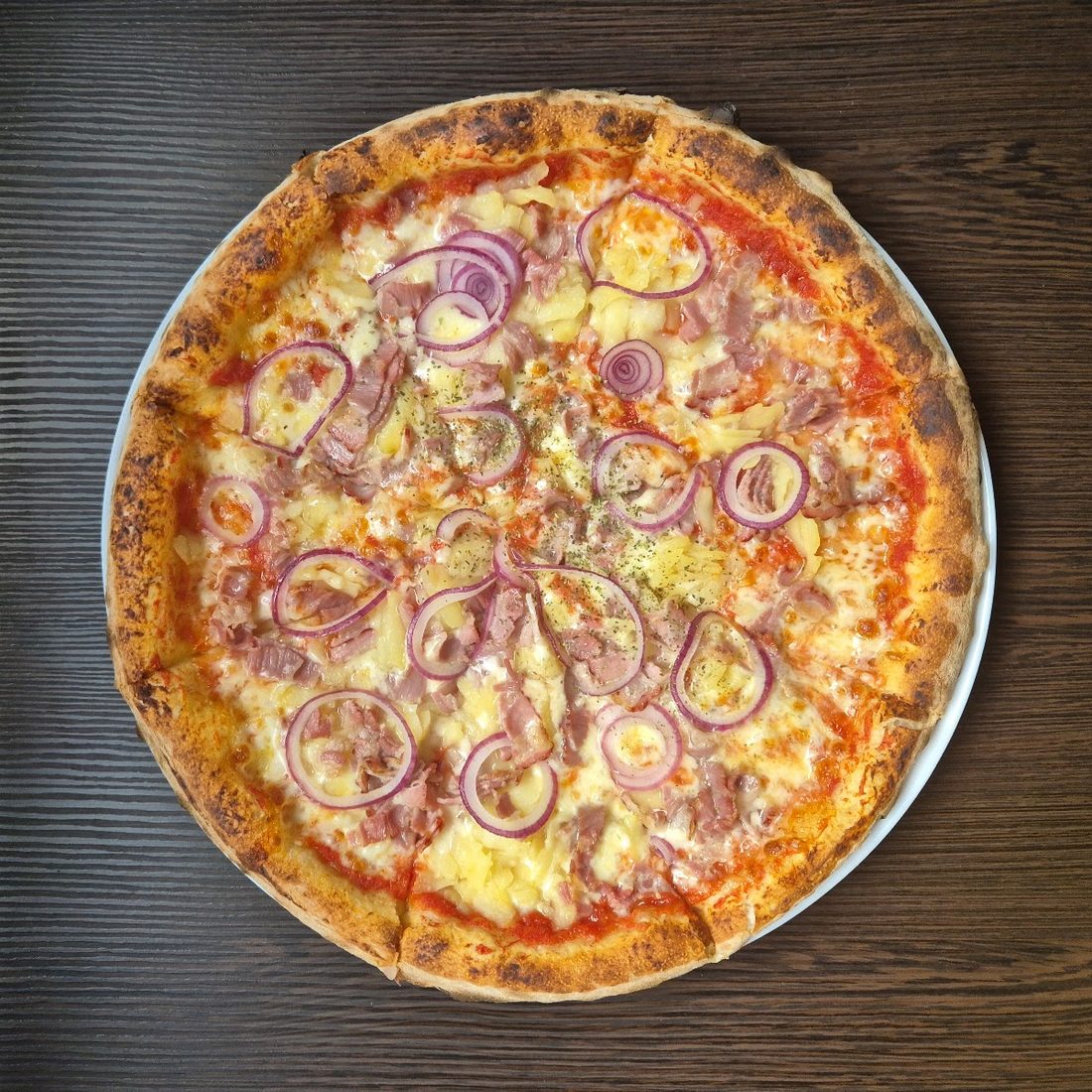 Pizza mit Schinken, Ananas und roten Zwiebeln von Pizza UNO Basel