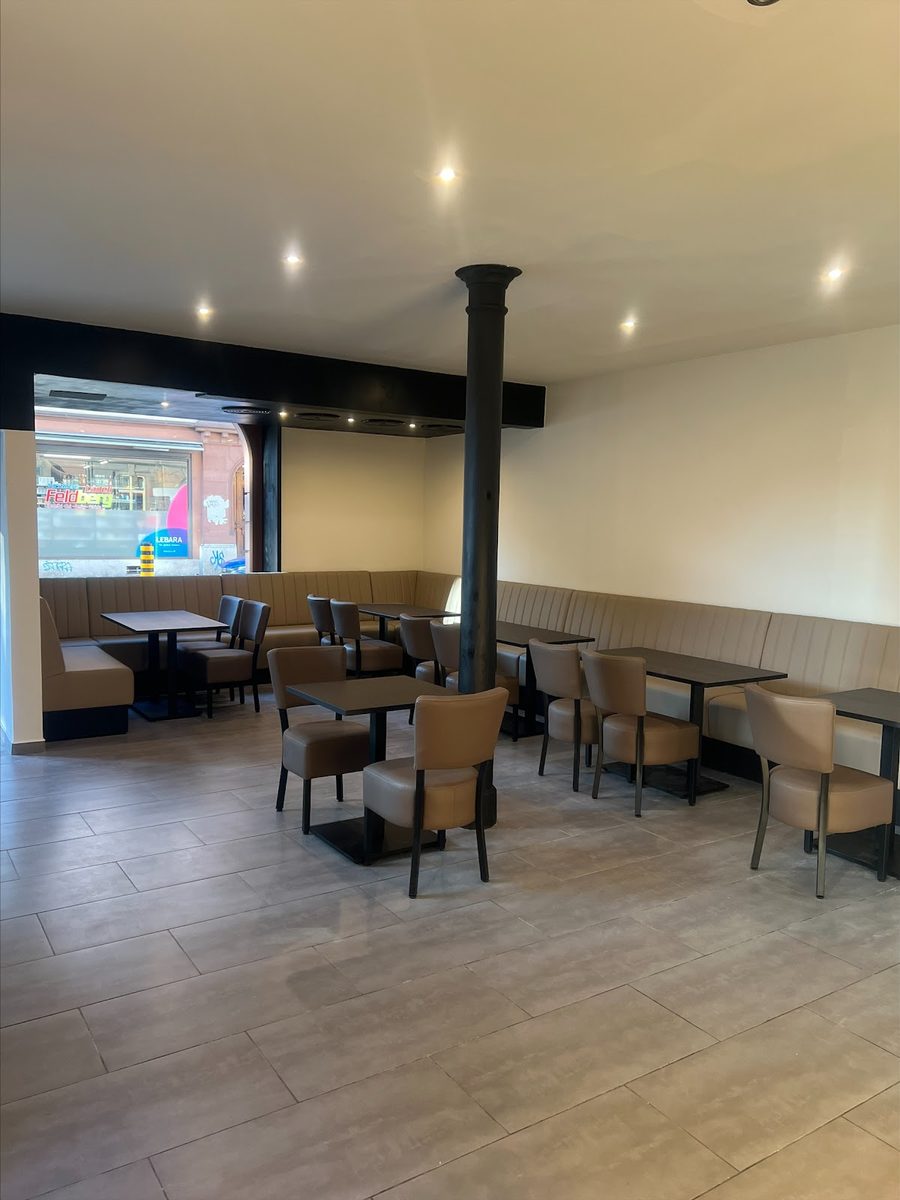 Gastraum von Pizza UNO Basel mit Sitzbänken und Tischen